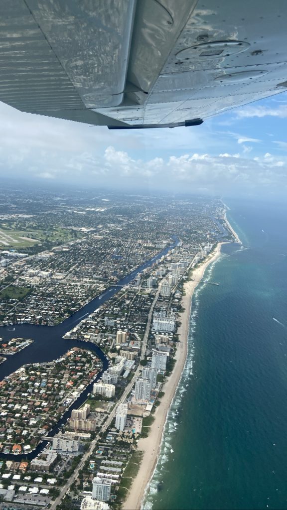 Cessna som flyr over Florida ved vannet